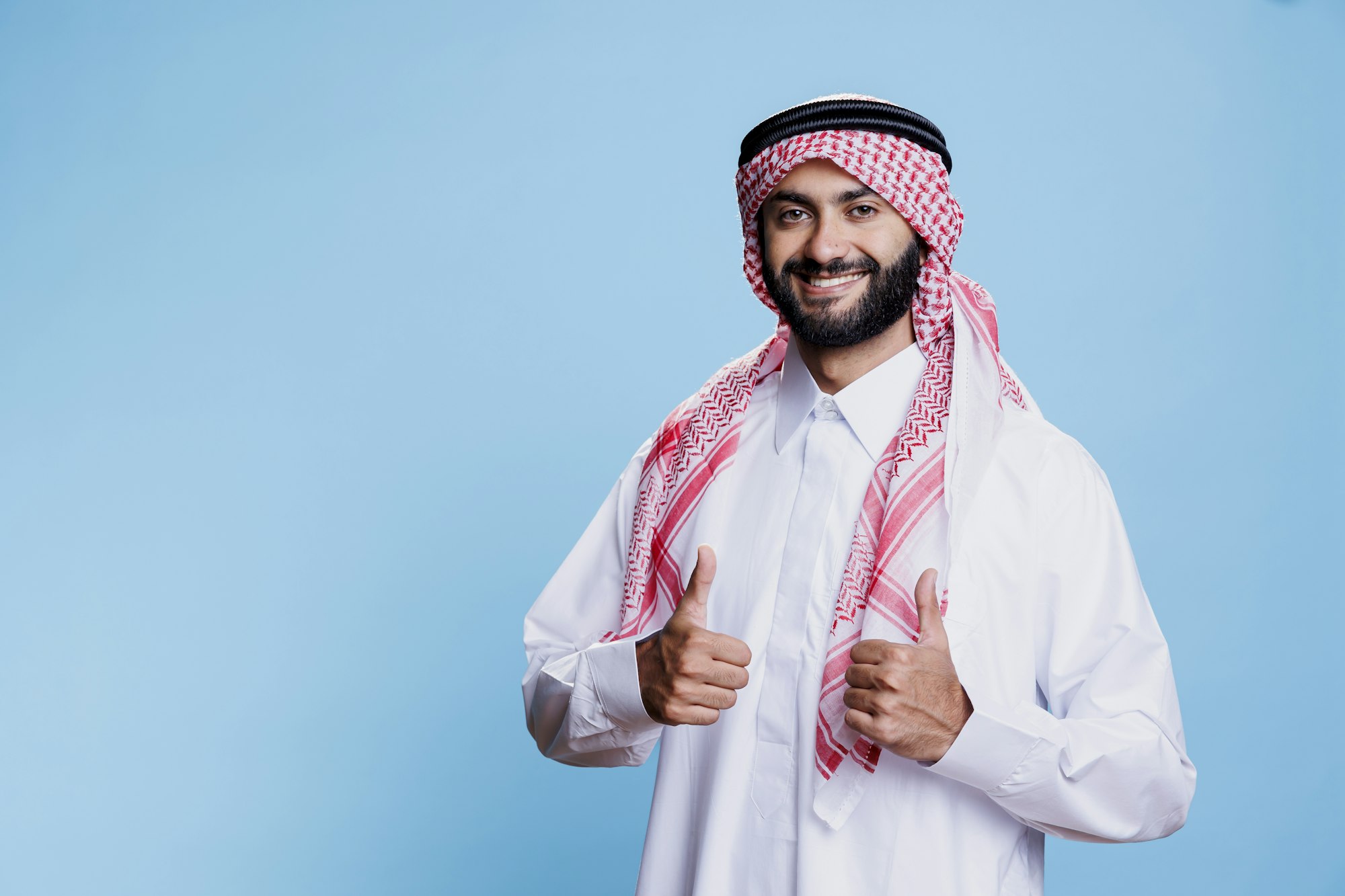 Man in islamic clothes giving thumbs up